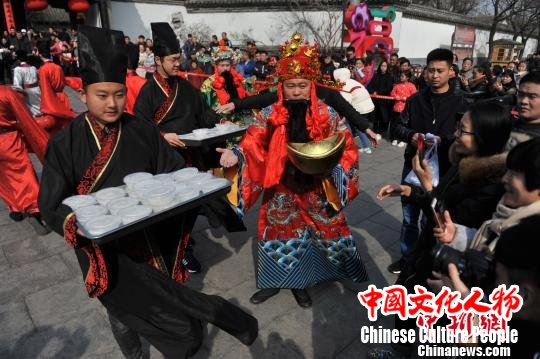 福禄寿”三星将祭祀圣果、糕点、灶糖分享给现场游客，景区工作人员送上一份份煮好的元宵，把孔府的福气带给大家。　梅花 摄