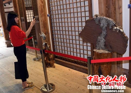 艺术家在传统元素的基础上大胆创新,将锡元素与木雕等不同材质有机结合,让人眼前一亮。 记者刘可耕 摄 艺术家在传统元素的基础上大胆创新,将锡元素与木雕等不同材质有机结合,让人眼前一亮。 记者刘可耕 摄