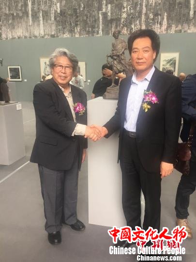 图为著名毛体书法家、广东惠州市文联主席安想珍与中国雕塑学会名誉会长曹春生和其创作的《农奴愤》雕塑作品前合影。　宋秀杰 摄