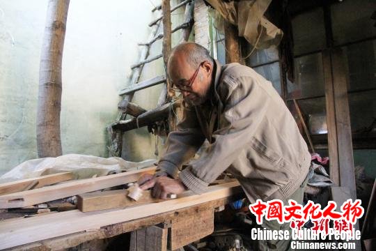 自18岁开始学习明式家具制作工艺，徐光祥与木头结伴近50年。徐光祥介绍说，该技艺由明初山西工匠带入济南市董家镇，在当地传承发展了几百年，保留了中国古代家具制作技艺中大量优秀木工工艺。图为徐光祥在刨木块。　郝学娟 摄