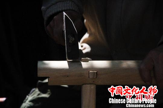 据了解，徐光祥已掌握30余种榫卯结构制作技艺。图为徐光祥组合榫卯结构桌腿。　郝学娟 摄