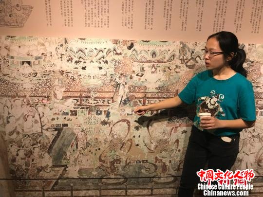 志愿者讲解壁画细节。　王子涛 摄